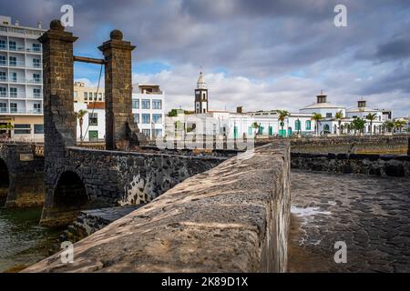 Puente de Las Bolas bridge, in backgrount, bell tower of church San Gines and town hall,  Lanzarote, spain Stock Photo