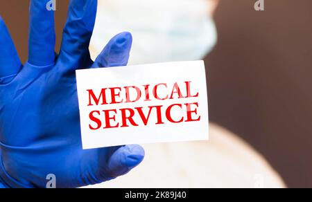 Medical concept. On a green surface, an ambulance, pills and a sign with the inscription - MEDICAL SERVICE. Stock Photo