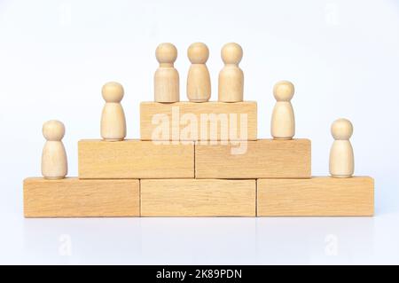 Wooden people figure on top of wooden blocks. Goal achievement, business growth and career progression. Stock Photo