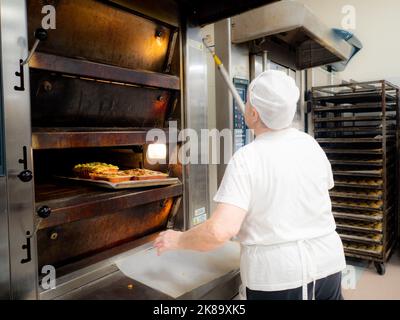 aged lady at work in big bakery restaurant Stock Photo