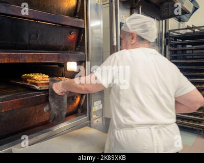 aged lady at work in big bakery restaurant Stock Photo