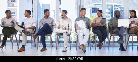 Lining up for Interviews. a group of people waiting to be interviewed for a job at a modern office. Stock Photo