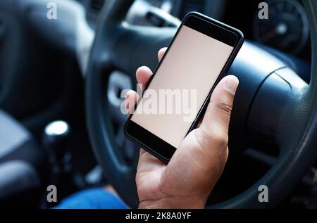 Its extremely dangerous to text and drive. someone siting in their car using their mobile. Stock Photo