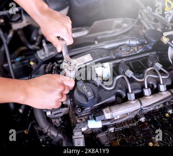 Car engine, mechanic hands and engineer wrench tools working on automobile performance. Young man motor technician, repair service and maintenance or Stock Photo