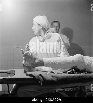 Cecil Beaton - The Western Desert 1942: An Army nurse caught in profile helping with a leg operation in the operating theatre in the General Hospital Stock Photo