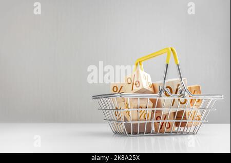 Advertisement, sale announcement. Shopping basket and boxes with sign discount percent. Sale Black Friday products on grey background. Concept of sell Stock Photo