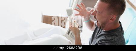 Middle aged man scream on someone over phone, man not satisfied with hotel service Stock Photo