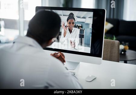 Its so good to see you. an unrecognizable businessman sitting alone in his office and having a virtual meeting with a coworker. Stock Photo