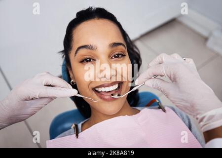 Going to the dentist has never felt so good. a young woman having dental work done on her teeth. Stock Photo