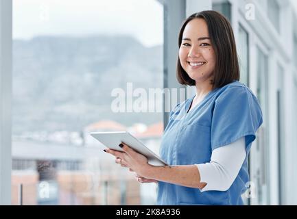 All I need can be accessed with such ease. Portrait of a medical practitioner using a digital tablet in a hospital. Stock Photo