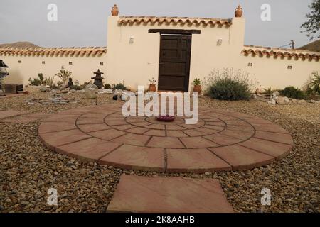 Rustic wall with old farm door, round terrace at the front Stock Photo