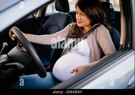 Caucasian pregnant woman driving a car Stock Photo