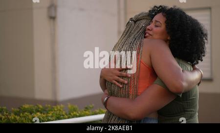 Female friend consoling desperate young woman. Two black sisters supporting each other. Friends embrace in crisis Stock Photo
