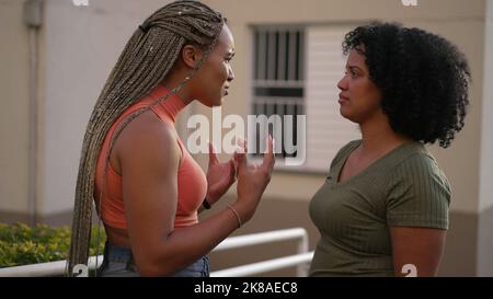 Female friend consoling desperate young woman. Two black sisters supporting each other. Friends embrace in crisis Stock Photo