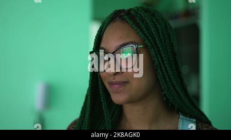 Foto de A happy black latin girl with green Box Braids hairstyle smiling at  camera do Stock