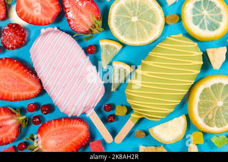 Two ice creams on a sticks - strawberry and lemon on a blue background. Summer fruit desserts. Stock Photo