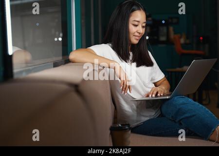 Happy cheerful female reading email on computer in the room indoors Stock Photo