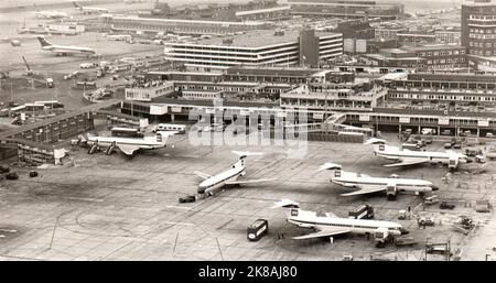 View from above of parking ramps of London Heathrow airport in late sixties. It is possible to identify several liner of different air companies, in particular some BEA Trident Three at gate. Stock Photo