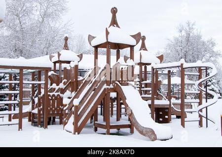 children's swing in winter in a park in the snow in Ukraine In the city of Dnipro, winter in the city Stock Photo