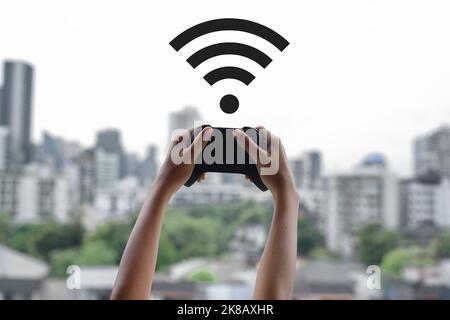 Girl looking for connection with a remote controller of a video game a a top of a building Stock Photo
