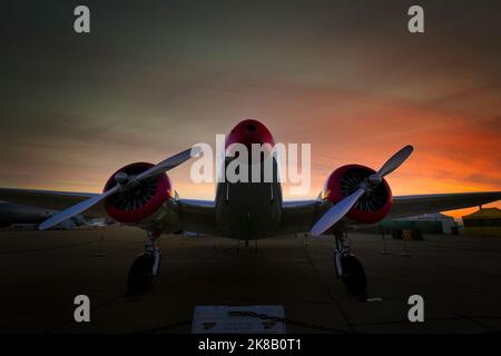 The sun rises behind a 1939 Lockheed 12A Electra Junior on display at the 2022 Miramar Airshow in San Diego, California. Stock Photo