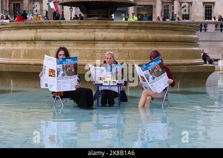 Trafalgar Square, London, UK. 22 October, 2022. A group of young females sit in the trafalgar fountain water holding mock Guardian newspapers with headline London homes underwater for 100th consecutive days. Photo Credit: Paul Lawrenson/Alamy Live News Stock Photo