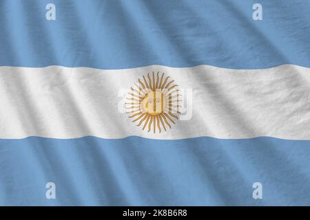 Argentina flag with big folds waving close up under the studio light indoors. The official symbols and colors in fabric banner Stock Photo