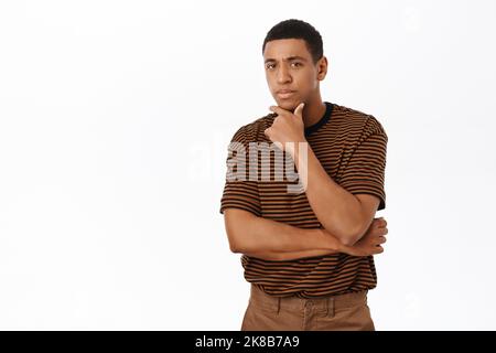 Image of man looking with thoughtful and concerned face, standing over white background Stock Photo