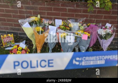 Washington Drive, Birmingham - October 22nd 2022 - A woman collapsed onto the ground with grief crying out for her 'brother' who was stabbed and killed on Washington Drive in Handsworth Wood just after 11pm last night (21 Oct). The 29-year-old victim, named locally as 'Jamie' was stabbed to death. The woman was consoled by a family friend as she screamed out in agony. Floral tributes and bottles of beer were left at the scene along with heartfelt messages from friends and family. Credit: Scott CM/Alamy Live News Stock Photo