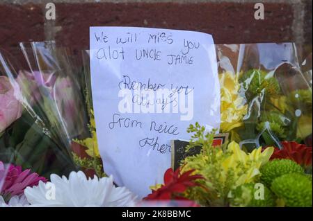 Washington Drive, Birmingham - October 22nd 2022 - A woman collapsed onto the ground with grief crying out for her 'brother' who was stabbed and killed on Washington Drive in Handsworth Wood just after 11pm last night (21 Oct). The 29-year-old victim, named locally as 'Jamie' was stabbed to death. The woman was consoled by a family friend as she screamed out in agony. Floral tributes and bottles of beer were left at the scene along with heartfelt messages from friends and family. Credit: Scott CM/Alamy Live News Stock Photo