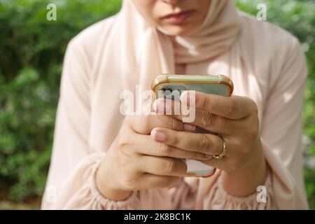 young women using smart phone sitting on park , selective focus  Stock Photo