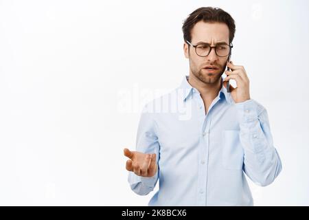 Businessman talking on mobile phone. Male entrepreneur calling someone, having a business call, standing over white background Stock Photo