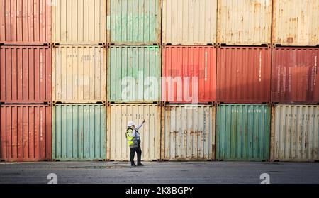 Logistics, shipping yard and cargo containers manager woman talking on phone for communication for import and export at a shipyard. Female engineer Stock Photo