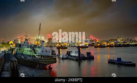 The wreck of the MV Royal Iris lies beached on the River Thames next to the Thames Barrier at night, London, UK. Stock Photo