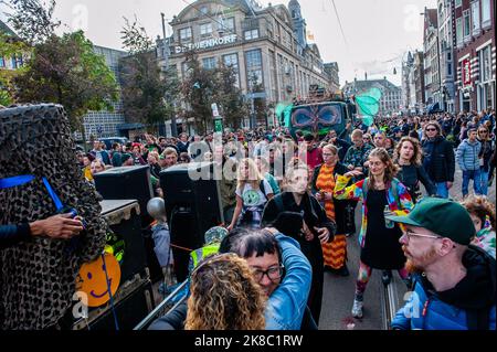 Thousands of people are seen dancing behind one of the trucks with music during the rally. ADEV (Amsterdam Danst Ergens Voor) which means something like 'Amsterdam Dances For Something' organized for the tenth time its annual demonstration for squatting, free spaces, and affordable housing in the city. Thousands of people danced accompanied by large trucks with loud music systems through the center of Amsterdam. Protesters danced to express their dissatisfaction with what they see as unaffordable housing and argue for more free spaces in the city, and also to be able to squat. Stock Photo