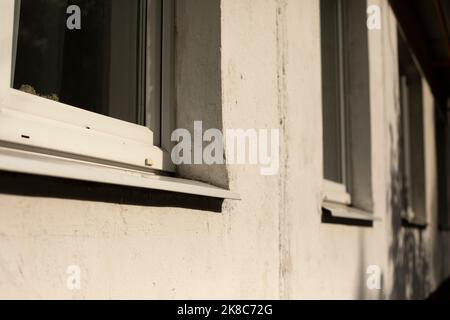 Window in building. Wall of house with windows. White house in city. Window sill details. Stock Photo