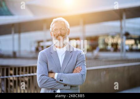 Confident happy mature older business man standing outdoors, portrait. Stock Photo