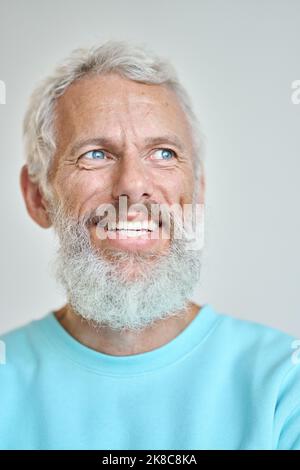Smiling senior old man looking away dreaming isolated on white. Vertical closeup Stock Photo