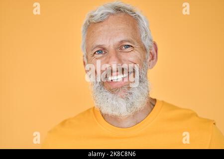 Smiling old senior man isolated on yellow background, headshot portrait. Stock Photo