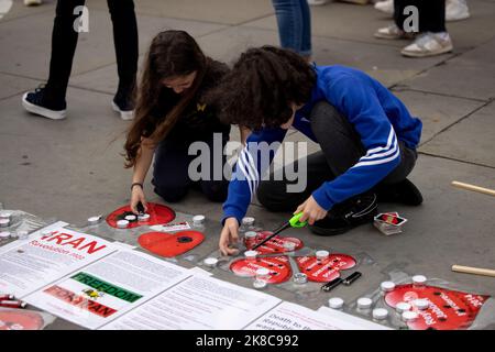 London, UK. 22nd Oct, 2022. Young children seen lighting candles at the vigil area in memory of the killed protesters in Iran in recent protests during the demonstration at Trafalgar Square. Iranians and Iraqi-Kurds residing in the UK and their supporters continue to protest on the streets and demand the UK government to stop supporting the brutality of the Iranian Islamic government after Mahsa Amini died in custody after being arrested by Iran's morality police for not wearing her headscarf in the proper manner. Credit: SOPA Images Limited/Alamy Live News Stock Photo
