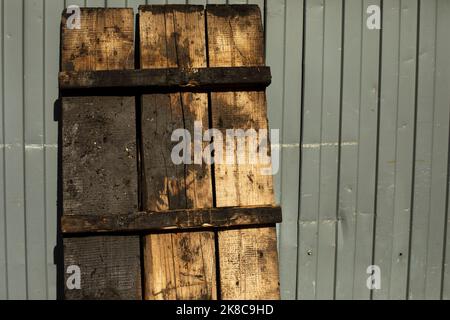 Pallet of wood stands against wall. Details of industrial area. Dirty pallet. Wooden bench. Stock Photo