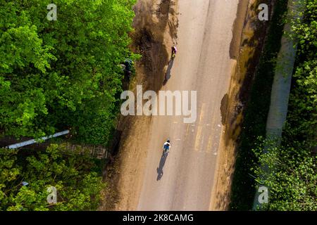 Children on bicycles on the roadway, top view from a height Stock Photo