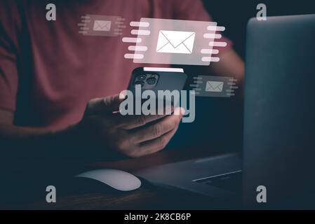 Businessman hands using Mobile Phone typing on keyboard and surfing the internet on office table with email icon, email marketing concept, send e-mail Stock Photo