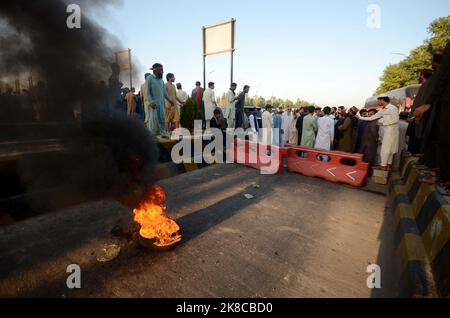 Peshawar, Khyber Pakhtunkhwa, Pakistan. 22nd Oct, 2022. Supporters of former Prime Minister Imran Khan's party chant slogans while blocking a Peshawar motorway toll plaza road as a protest against the Election Commission's decision to disqualify their leader Khan, in Peshawar, Pakistan. Pakistan's elections commission on Friday disqualified former Prime Minister Imran Khan from holding public office on charges of unlawfully selling state gifts to him and concealing assets, his spokesman said. The move is likely to deepen lingering political turmoil in the impoverished country. (Credit Image: C Stock Photo