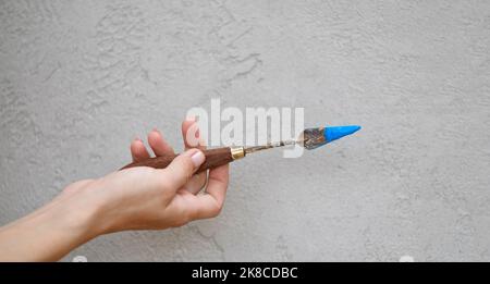 Spatulas for acrylic paints on grey wall background. Spatulas stained with paint. Copy space or banner Stock Photo