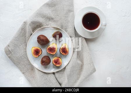 Still life with coffee cup and figs on white textured table. Top view, flat lay. Stock Photo