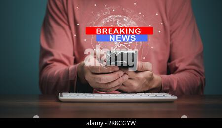 Breaking News, broadcast channels or internet tv concept, Man holding Mobile phone with World Global news background design. Stock Photo