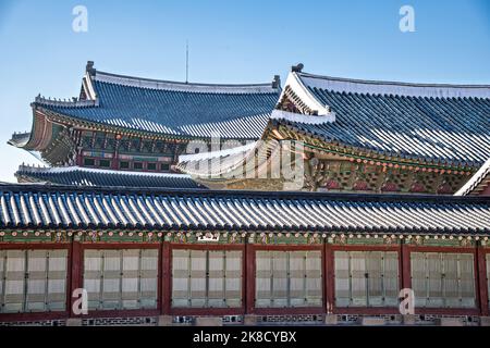 Traditional Korean roofs dusted with snow at the Gyeongbokgung Palace during winter in Seoul, South Korea. Stock Photo