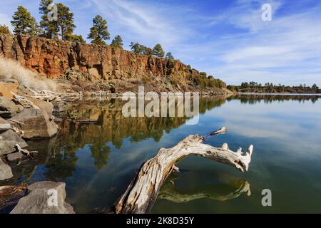 The calm waters of Fool Hollow Lake reflect the cliffs and sky.   (Fool Hollow Lake, Recreation Area, Show Low, Arizona.) Stock Photo