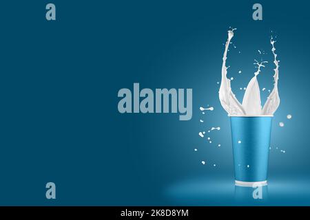 Paper cups with milk splashes on colorful background. Disposable cup with white milk splashes. Stock Photo